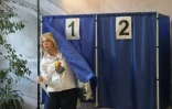 Une femme sort d'un isoloir après avoir voté aux élections législatives russes dans un bureau de vote de Donetsk, dans l'est de l'Ukraine sous contrôle russe, le 18 septembre 2026