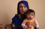Jahantab Ahmadi, une Afghane déterminée à faire des études dont la photo a ému tout le pays, avec son plus jeune enfant lors d'un entretien avec l'AFP à Kaboul, 24 mars 2018