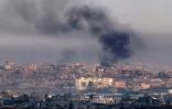 Photo prise depuis le côté israélien de la frontière avec la bande de Gaza montrant de la fumée s’élevant au-dessus de bâtiments détruits, lors d’un bombardement israélien dans le territoire palestinien assiégé, le 22 mai 2025