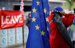 Un opposant au Brexit avec un drapeau européen près d'une banderole en faveur du Brexit devant le Parlement à Londres le 17 octobre 2019 