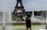 Une femme se rafraîchit dans les fontaines du Trocadéro près de la Tour Eiffel à Paris, le 22 juillet 2019
