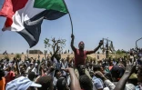 Des manifestants brandissent le drapeau soudanais lors d'un sit-in devant le QG de l'armée à Khartoum, le 22 avril 2019
