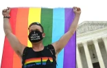 Un homme brandit un drapeau arc-en-ciel devant la Cour suprême, à Washington, le 15 juin 2020