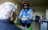 Un membre du club de motards "Hope Bikers Syria" distribue des repas pour l'iftar Ă des personnes dans le besoin, pendant le ramadan, le 25 mars 2024 Ă Damas, en Syrie