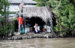 Un Vietnamien salue le passage d'un bateau où se trouve le secrétaire d'Etat américain John Kerry, sur le delta de la rivière du Mekong, le 14 janvier 2017
