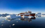 Un bateau de touristes au milieu des icebergs dans la baie de Disko, le 1er juillet 2022 à Ilulissat, au Groenland