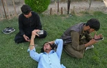 Des jeunes Afghans consultent leurs smartphones sur la colline de Wazir Akbar Khan, à Kaboul, le 10 août 2026