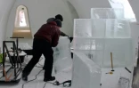 Un employé apporte la touche finale à une pièce du Arctic Snow Hotel, un hôtel fait de glace, le 17 décembre 2020 à Rovaniemi, en Laponie finlandaise