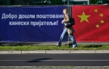 Un piéton passe devant un drapeau chinois et l'inscription en serbe "Bienvenue chers amis chinois" à Belgrade le 7 mai 2024, à la veille de la visite du président chinois en Serbie.