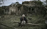 Femme devant des maisons en ruines à Druzhkivka dans l'est de l'Ukraine, le 5 juin 2022