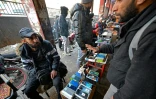 Un vendeur de téléphones parle avec un client dans une rue de Damas, le 12 janvier 2025 en Syrie