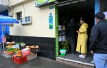 Des clients dans un magasin plongé dans la pénombre en raison des rationnements d'électricité, le 19 avril 2024 à Quito, en Equateur