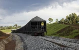 Un employé de la compagnie chinoise China Railway 18th Bureau Group à l'arrière d'un train transportant des pierres à la mine de Simfer, dans les montagnes de Simandou, le 2 septembre 2025 en Guinée