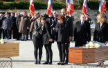 Edouard Philippe, Gérard Collomb et Nicole Belloubet se tiennent derrière des membres de la famille d'une des victimes des attentats de l'Aude lors d'un hommage solennel à Trèbes, le 29 mars 2018