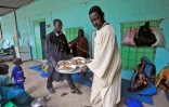 Des déplacés soudanais servent de la nourriture dans le camp qui abrite des milliers de personnes ayant fui les violences dans le sud du pays, le 7 août 2022