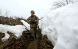 Un soldat ukrainien patrouille dans une tranchée sur la ligne de front, le 11 janvier 2022 près de Luganske, dans la région de Donetsk