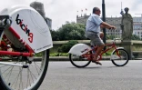 Un homme fait du vélo en libre-service à Barcelone, le 18 juin 2007