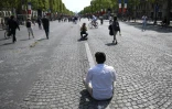 Un homme se fait photographier sur l'avenue des Champs-Elysees à Paris le 8 mai 2016 à l'occasion d'une journée sans voiture sur la célèbre avenue qui se reproduira un dimanche par mois