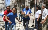 Un volontaire de la Défense civile syrienne porte un enfant blessé par les bombardements à Alep le 23 juillet 2016