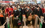 Des voyageurs portant des masques de protection contre le coronavirus s'apprêtent à monter dans un train à destination de Wuhan, le 28 mars 2020 à la gare de Shanghai