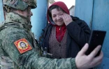 Valentina Martchenko, 61 ans, une habitante du village de Kazatchïa Loknïa, village de la région de Koursk (Russie) repris aux forces ukrainiennes, alors qu'un soldat russe lui permet d'échanger avec sa famille, le 19 mars 2025
