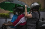 Des personnes à moto sous une pluie battante avant l'arrivée de la tempête Pamela, qui devrait se transformer en ouragan, le 12 octobre 2021 à Culiacan, au Mexique