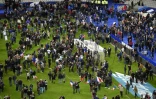 Les supporters de football se réunissent sur le terrain du Stade de France en attendant leur évacuation le 13 novembre 2015 à Paris
