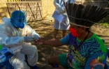 Des soignants procèdent à un test au Covid-19 sur le chef Leno de la tribu Kunaruara, près de Santarem, dans l'Etat du Para, au Brésil, le 10 juillet 2020