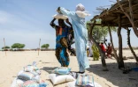 Une femme porte des sacs de maïs lors d'une distribution d'aide par le Comité international de la Croix-Rouge, dans un camp de déplacés à Kiskra, dans la province du lac Tchad, au Tchad, le 19 juin 2025
