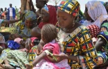 Au Niger, une mère utilise un périmètre brachial (PB), un brassard tricolore, qui sert à mesurer l'épaisseur du bras et détecter la malnutrition, dans le village de Barago (sud), le 14 juillet 2016 