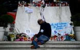 Un homme prie devant un autel improvisé au pied de la statue de Jean-Paul II devant l'hôpital Gemelli, à Rome, où est hospitalisé le pape François, le 28 février 2025