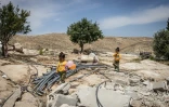 Deux fillettes palestiniennes marchent dans les décombres du hameau de Khallet Al-Dabaa, en Cisjordanie occupée, le 6 mai 2025, après la destruction par les forces israéliennes des maisons de ce village