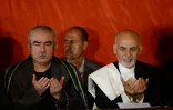 Abdul Rachid Dostom (G) prie en compagnie d'Ashraf Ghani, alors candidat à la présidence de l'Afghanistan, le 25 juin 2014 lors d'une conférence de presse à Kaboul