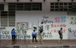 Nettoyage de graffitis inscrits par des manifestants pro-démocratie, à Hong Kong, le 30 septembre 2019