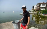 Nikola Paskali, plongeur et archéologue, ramasse des déchets sur la plage près du lac Ohrid, le 22 juin 2021 en Macédoine du Nord
