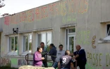 Des salariés de l'équipementier automobile creusois GM&S, devant le site de la Souterraine où est inscrit un graffiti "283 familles sacrifiées par des patrons voyous" 