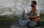 L'artiste brésilien Mundano tamisant la cendre d'Amazonie pour sa fresque à Sao Paulo le 13 octobre 2021