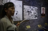 Une guide montre à des visiteurs des photos d'ossements au musée des atrocités de guerre américaines, le 24 juillet 2018 à Sinchon, en Corée du Nord