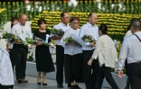Des invités attentent de pouvoir déposer un bouquet de fleurs au niveau du cénotaphe commémorant le bombardement atomique de 1945, le 6 août 2025 à Hiroshima au Japon