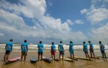 Des surfeurs parlestiniens s'apprêtent à partir à l'assaut des vagues depuis la plage à Gaza, le 22 juin 2022