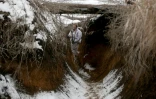 Un soldat ukrainien marche dans une tranchée près de la ligne de front avec les séparatistes pro-russes dans la région de Donetsk le 31 janvier 2022