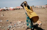Une femme porte un jerrycan d'eau dans un camp de déplacés à Baidoa (Somalie), le 13 février 2022