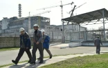 Des employés devant le sarcophage de la centrale nucléaire de Tchernoby le 8 avril 2016