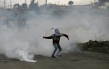 Un Palestinien lance une grenade lacrymogène sur des forces israéliennes près de la colonie israélienne de Beit El, en Cisjordanie occupée, le 23 janvier 2018