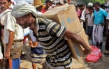 Un homme transporte sur son dos des boites d'aide humanitaire dans la province de Hajjah, au Yémen, le 25 septembre 2018