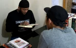 Sandi Widodo fait réciter des versets du Coran à ses clients dans son établissement d'effacement de tatouages, le 18 avril 2018 à Jakarta, en Indonésie
