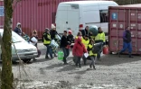 Des migrants accompagnés par des membres d'associations arrivent au camp de Grand-Synthe dans le nord de la France, le 7 mars 2016