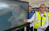 Steven Yiu, directeur exécutif des opérations aéroportuaires de l'Autorité aéroportuaire de Hong Kong, montre sur un écran l'endroit où un avion cargo Boeing a dérapé dans la mer après avoir heurté un véhicule au sol lors de son atterrissage sur la piste nord de l'aéroport de Hong Kong, le 20 octobre 2025