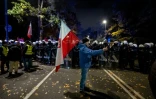 Un manifestant tient un drapeau polonais face à un cordon de policier près de la Cour constitutionnelle, le 30 octobre 2026 à Varsovie