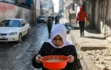 Une jeune fille transporte une bassine de soupe aux lentilles à Rafah, dans le sud de la bande de Gaza, le 6 février 2024